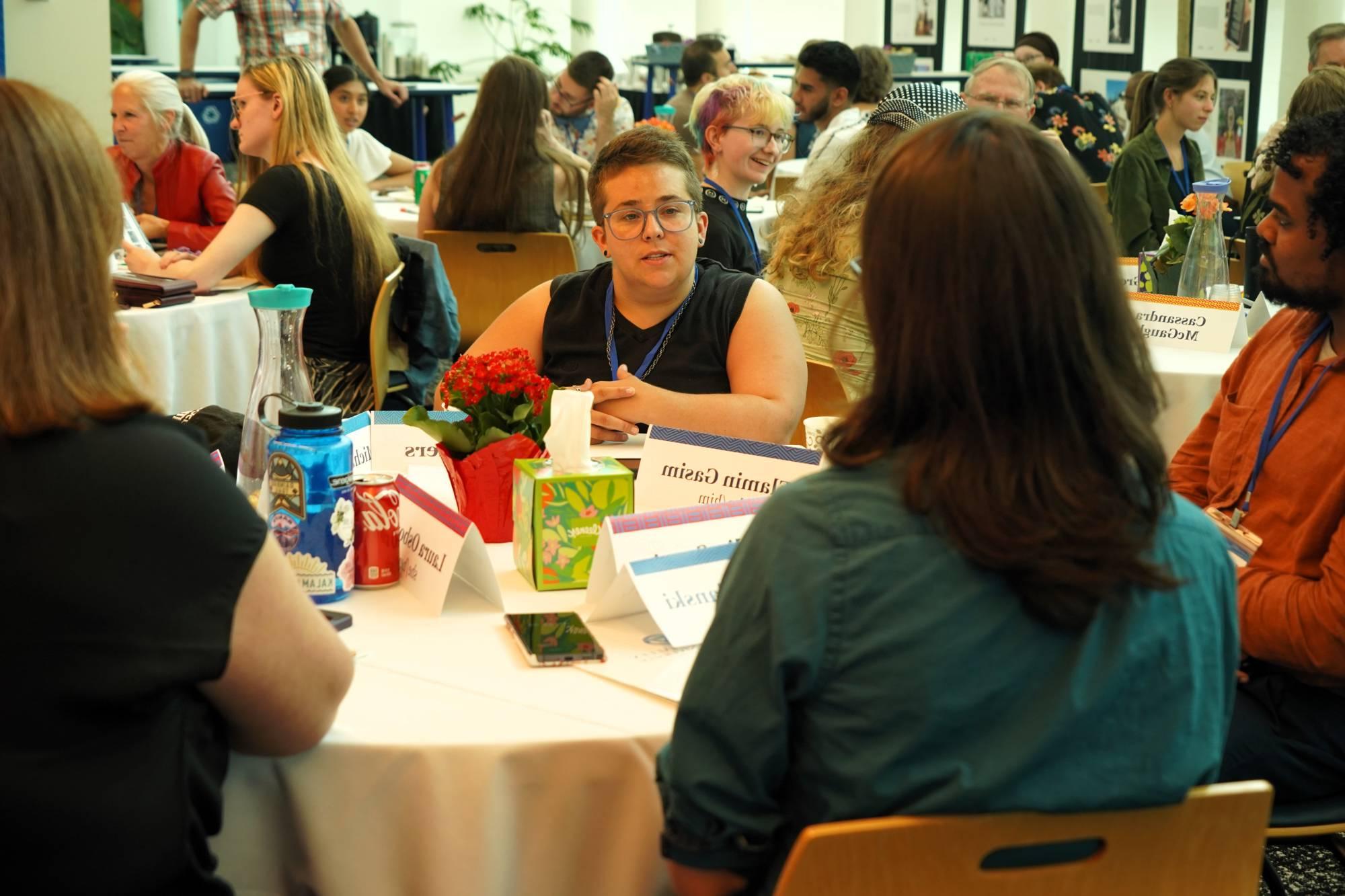 Group of people engaged in conversation around a table